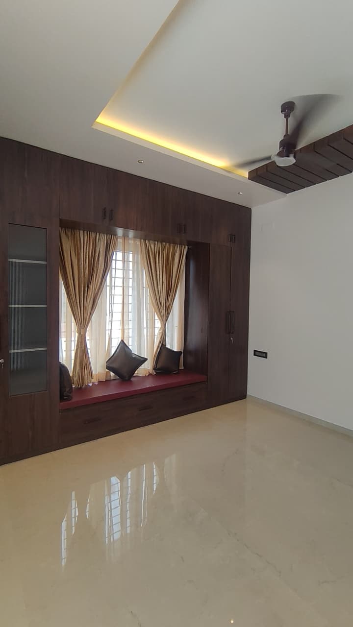 Bedroom wardrobe design Coimbatore – frosted glass doors and integrated window bench