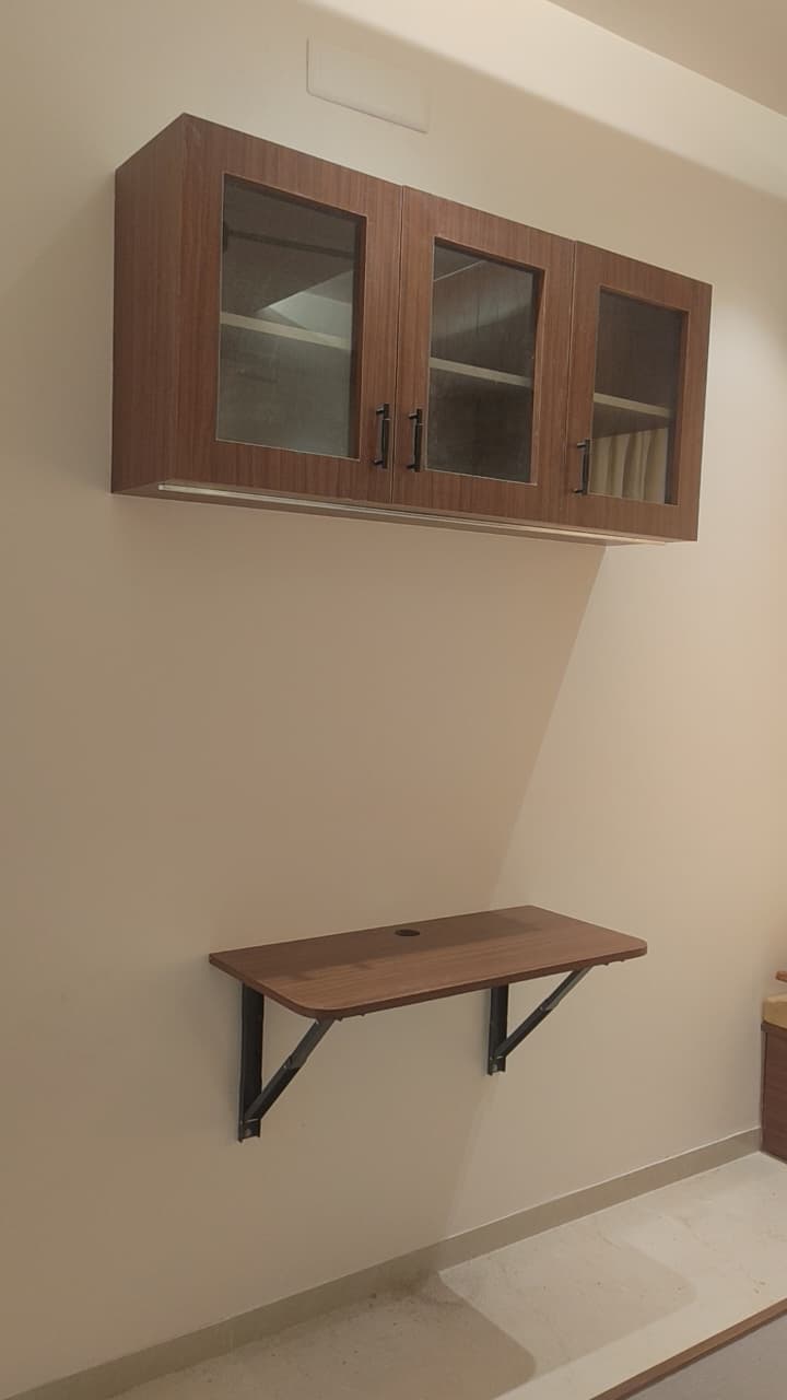 Compact wall-mounted study desk with overhead glass cabinets – home office Coimbatore villa