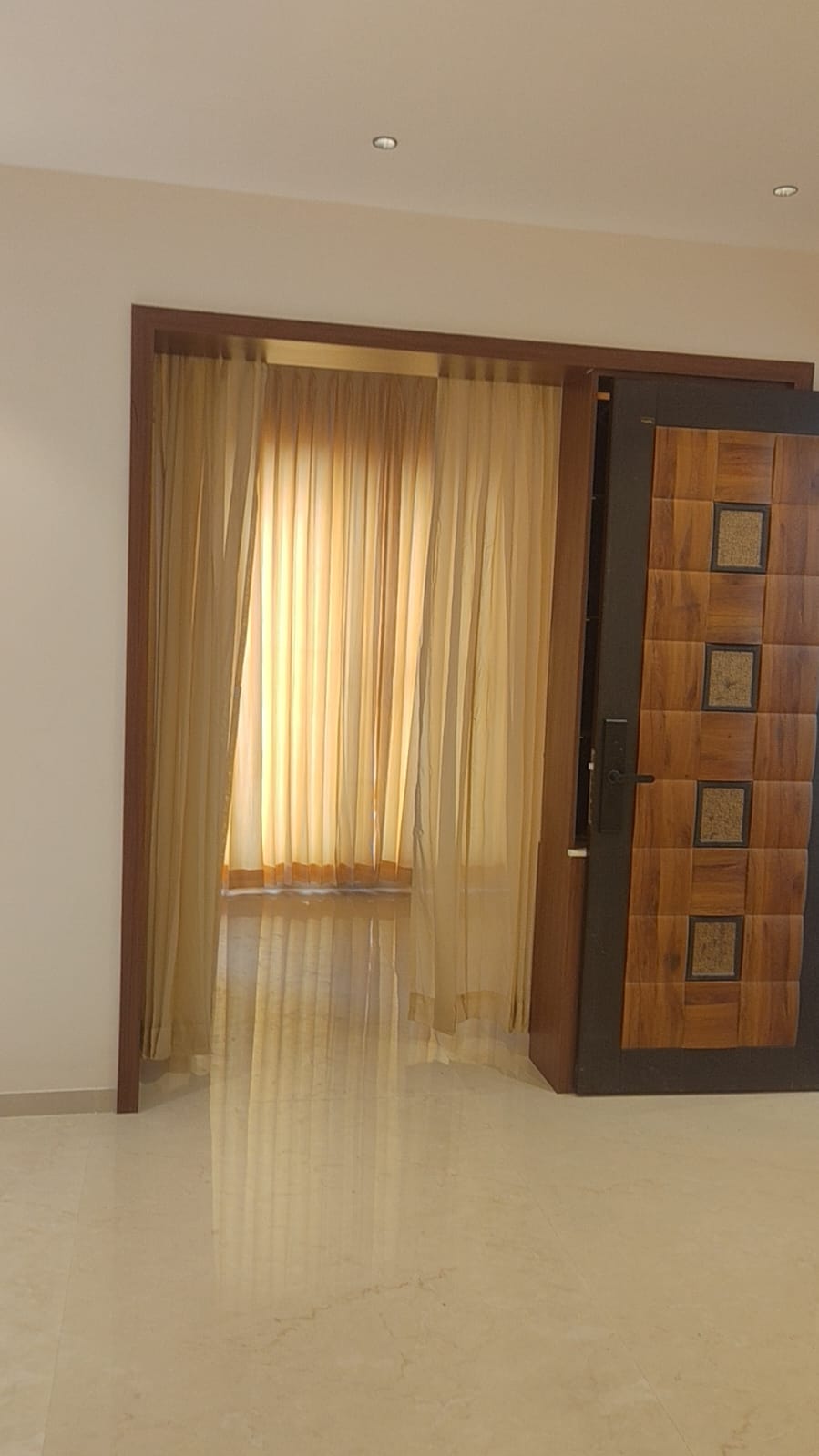 Villa entrance interior Coimbatore – sheer curtains, polished marble floor and designer doorway