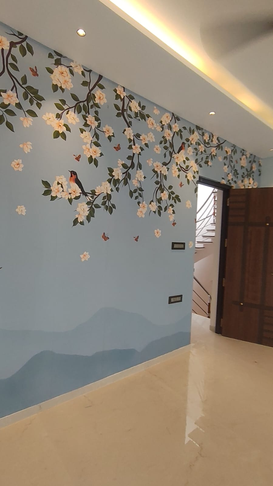 Villa hallway blossom mural and staircase door – interior design Coimbatore Tamil Nadu