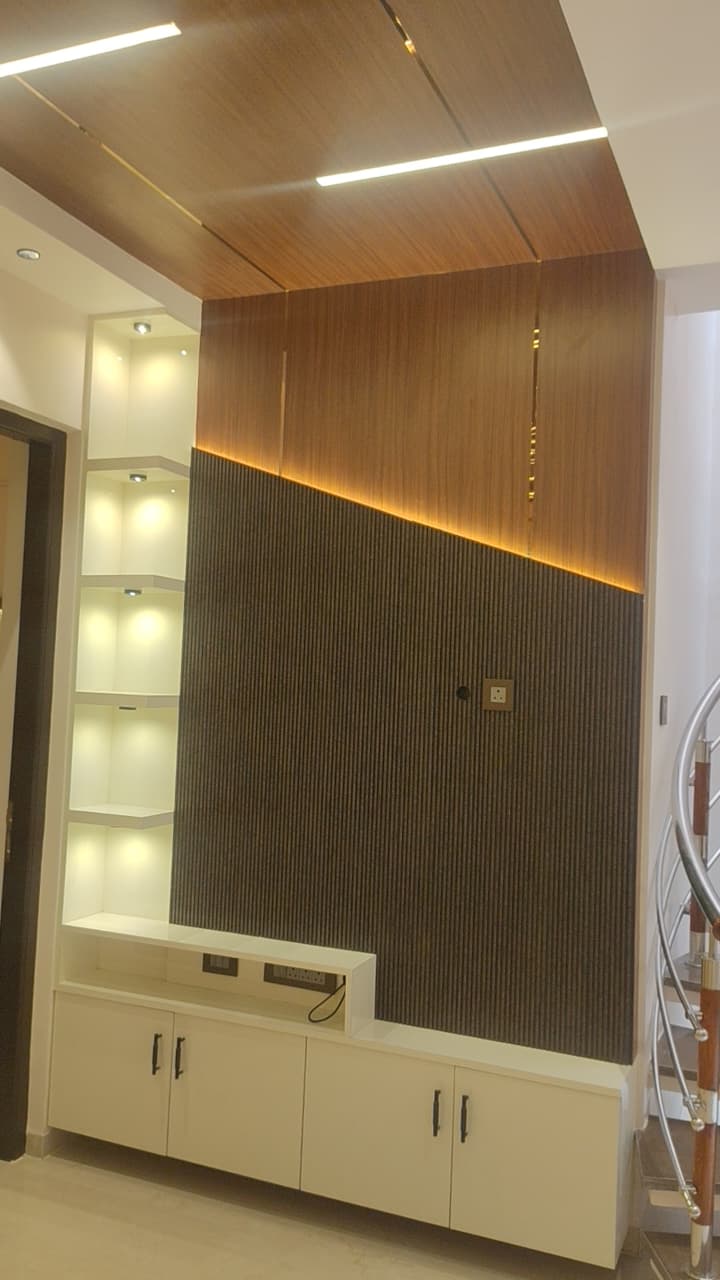 TV unit design Coimbatore – fluted panel feature wall with LED strip lighting and display shelves