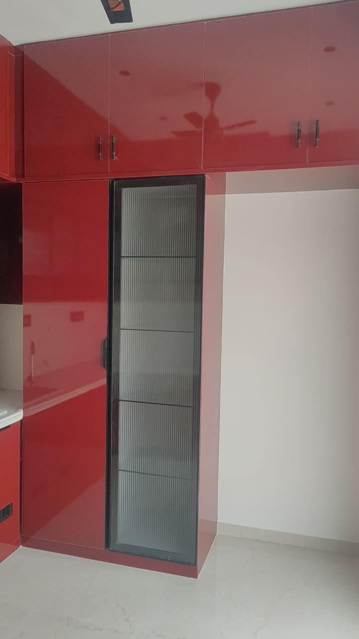 Modern modular kitchen Coimbatore – red glossy shutters with fluted glass tall unit