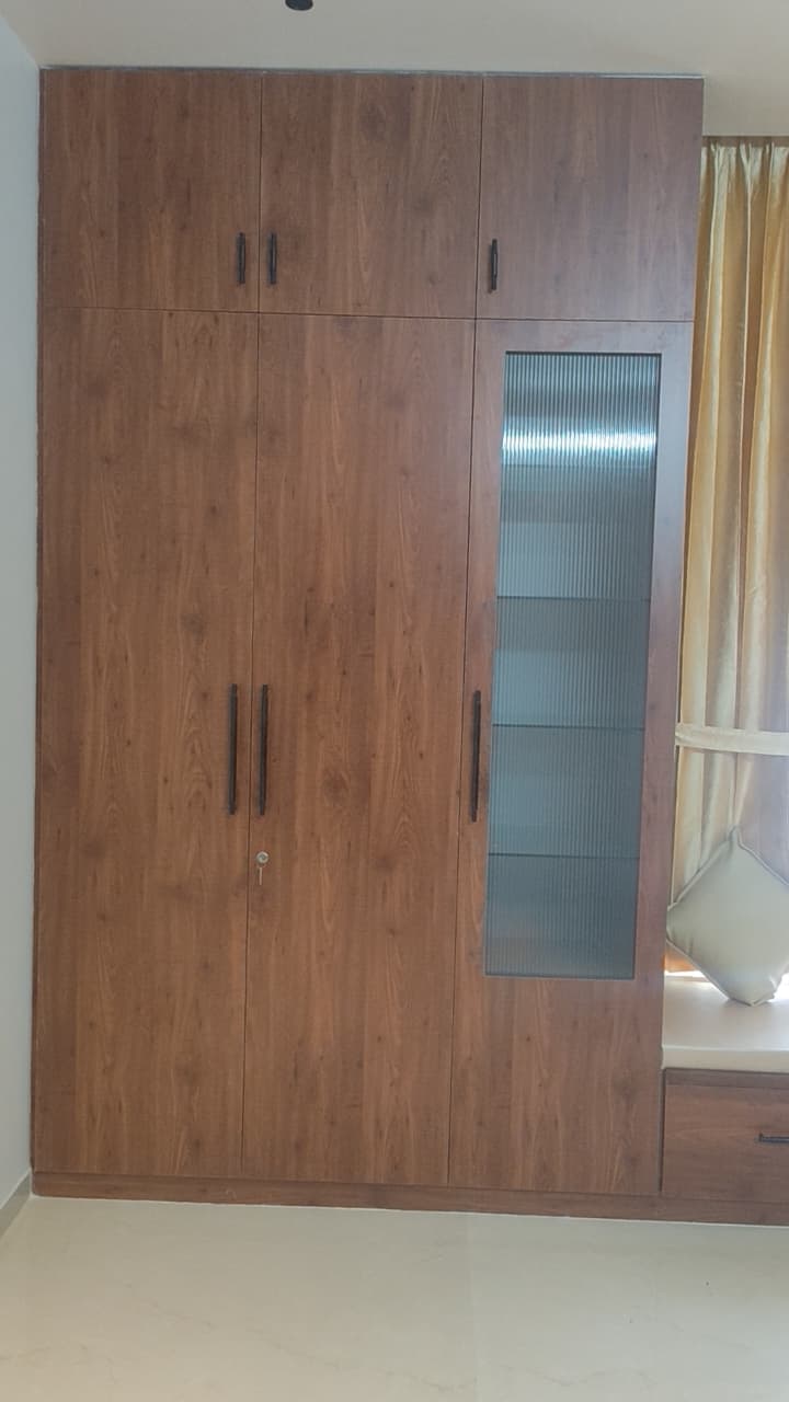 Custom wardrobe with fluted glass and window seat – Jayalakshmi Interiors Coimbatore